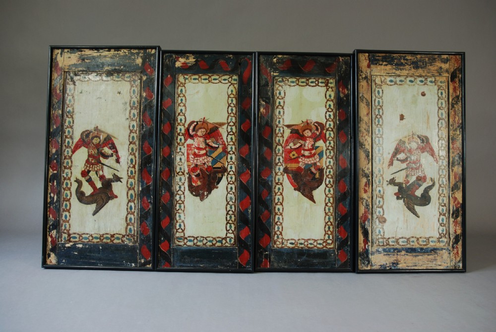 A set of four rectangular vertical pine panels decorated with naive paintings of Saint Michael slaying a winged dragon within chainlink borders. View VII