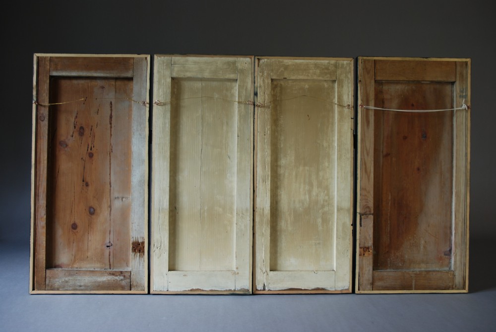A set of four rectangular vertical pine panels decorated with naive paintings of Saint Michael slaying a winged dragon within chainlink borders. View XII