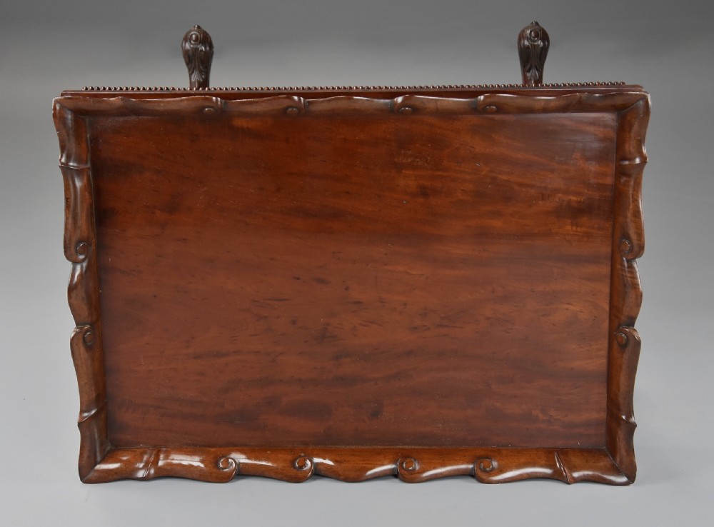 An early 19th century Regency mahogany work table featuring a wavy galleried tray top, flame mahogany apron with bead moulding, turned supports, and a carved stretcher base. View XII