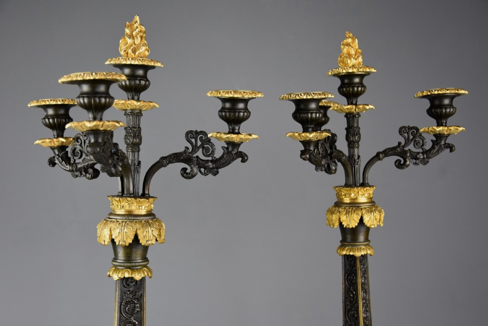A pair of mid-19th century French Regence style candelabra crafted from patinated dark bronze with gilt bronze foliage mounts and three scrolled branches. View IV