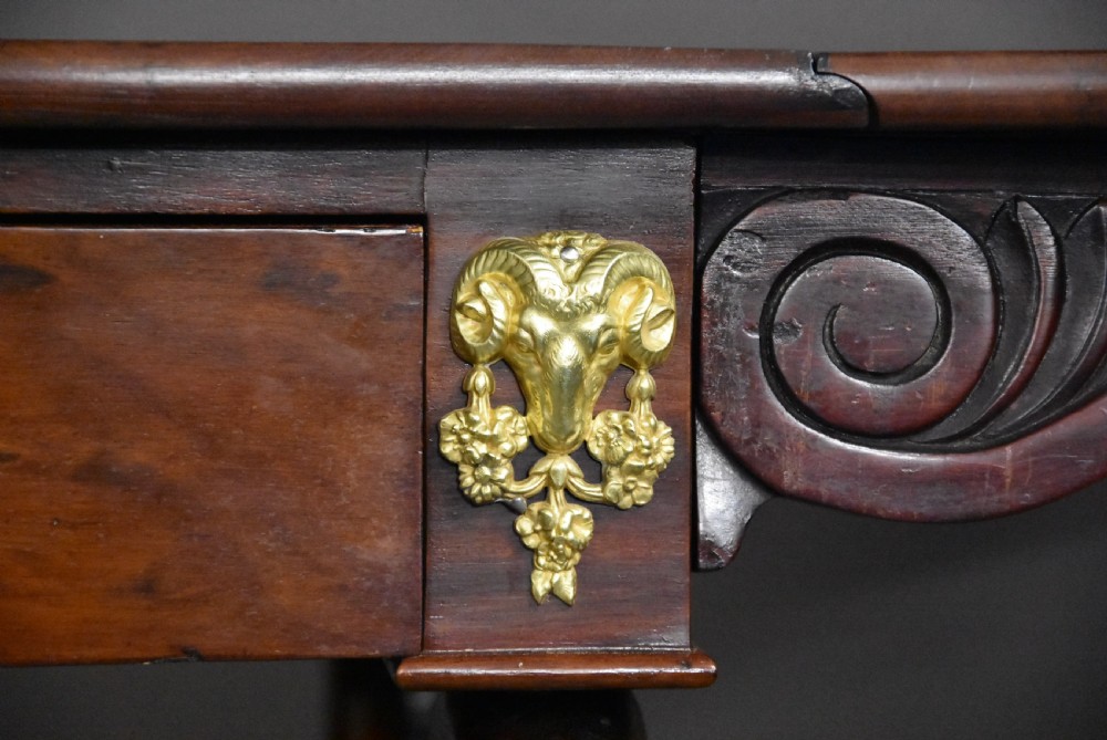 An early nineteenth-century French Empire mahogany sofa table featuring two drop leaves, a drawer with brass mounts, carved legs, and a turned central stretcher. View VI
