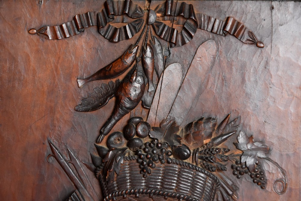 A framed mid-19th-century Continental fruitwood panel featuring a high-relief carved vertical trophy motif of hunting equipment, fruit, and foliage. View VI