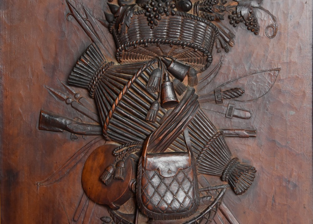 A framed mid-19th-century Continental fruitwood panel featuring a high-relief carved vertical trophy motif of hunting equipment, fruit, and foliage. View VII