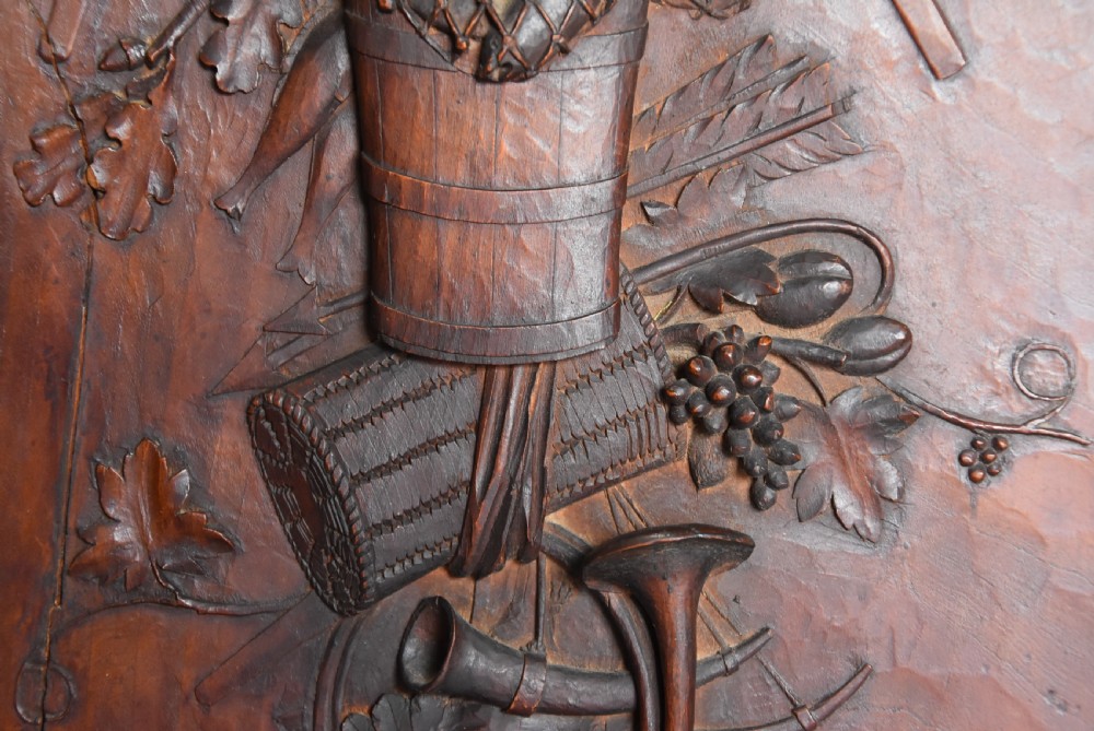 A framed mid-19th-century Continental fruitwood panel featuring a high-relief carved vertical trophy motif of hunting equipment, fruit, and foliage. View IX