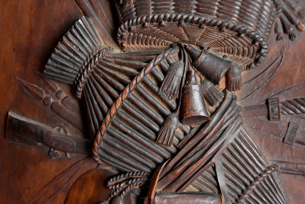 A framed mid-19th-century Continental fruitwood panel featuring a high-relief carved vertical trophy motif of hunting equipment, fruit, and foliage. View X
