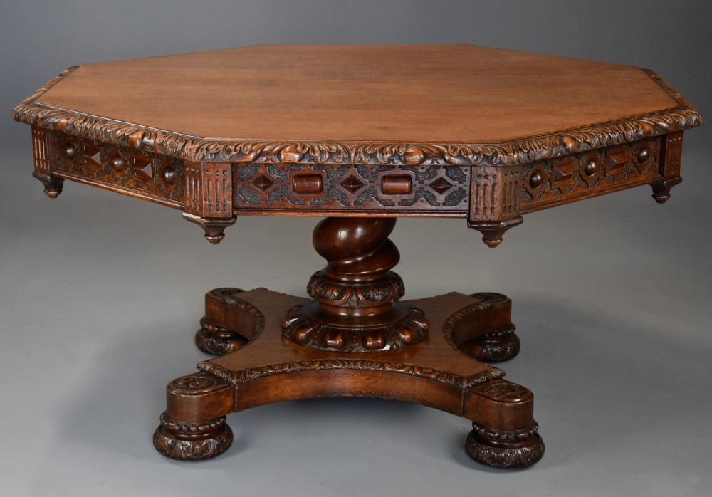 An early 19th-century octagonal carved oak library table with a central spiral pedestal and geometric strapwork frieze. View II