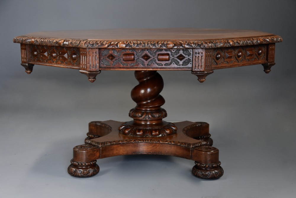 An early 19th-century octagonal carved oak library table with a central spiral pedestal and geometric strapwork frieze. View IV