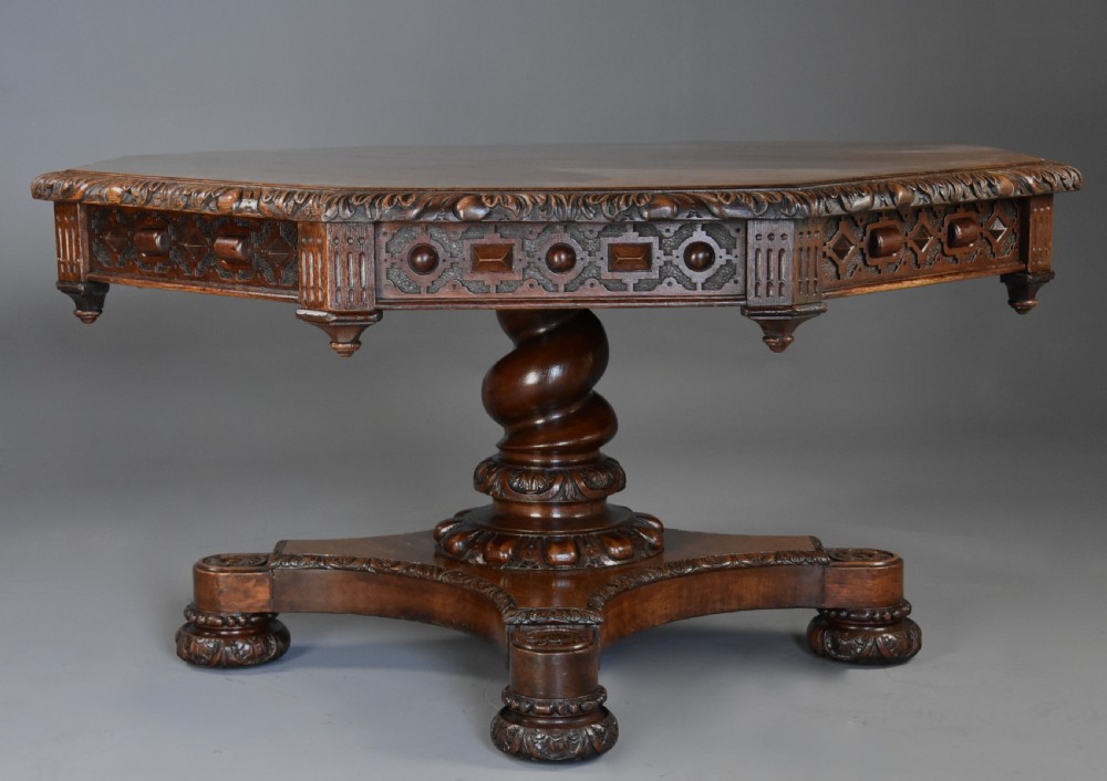 An early 19th-century octagonal carved oak library table with a central spiral pedestal and geometric strapwork frieze. View V