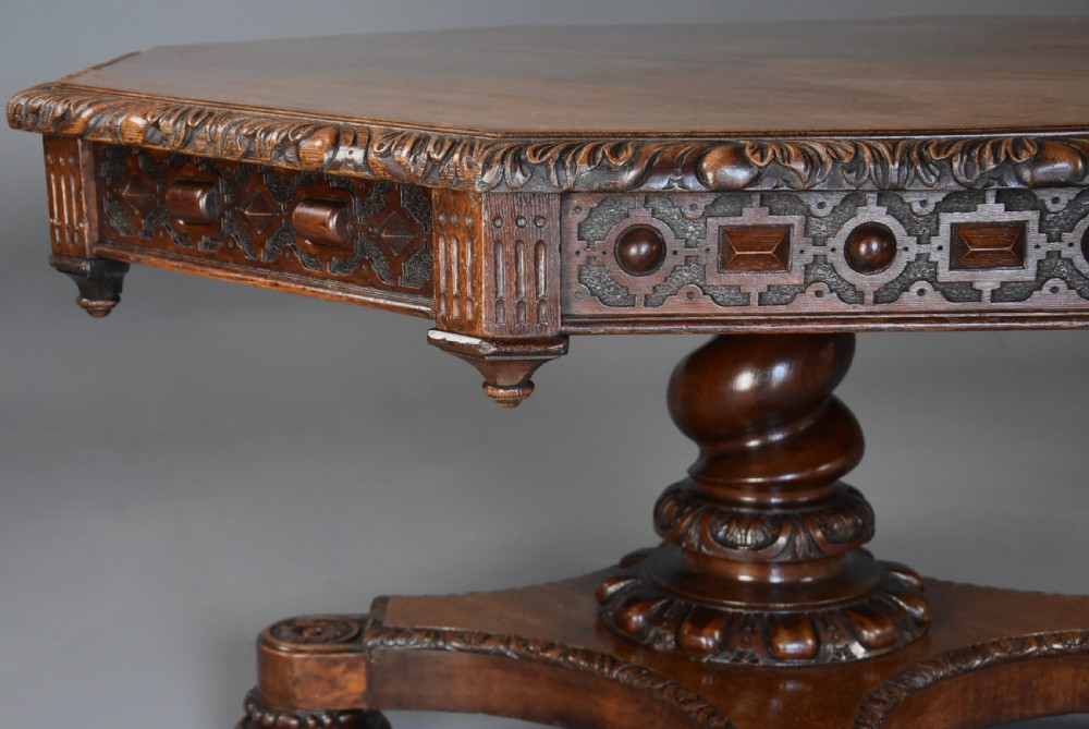 An early 19th-century octagonal carved oak library table with a central spiral pedestal and geometric strapwork frieze. View VIII