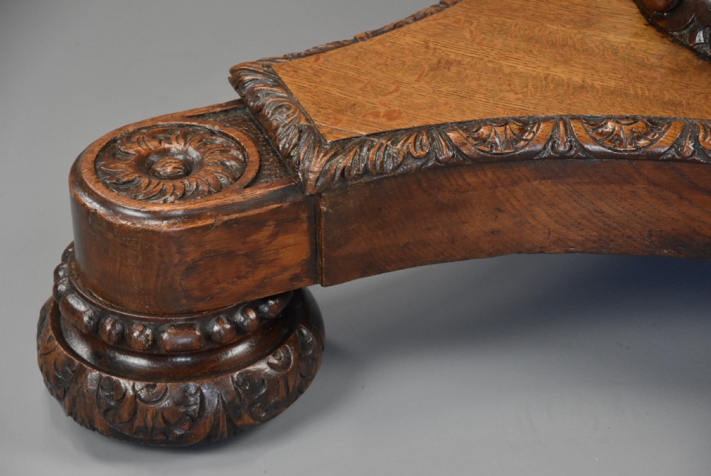 An early 19th-century octagonal carved oak library table with a central spiral pedestal and geometric strapwork frieze. View XV