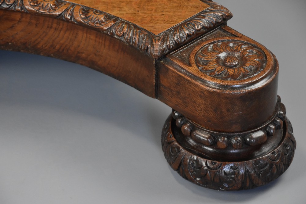 An early 19th-century octagonal carved oak library table with a central spiral pedestal and geometric strapwork frieze. View XVI