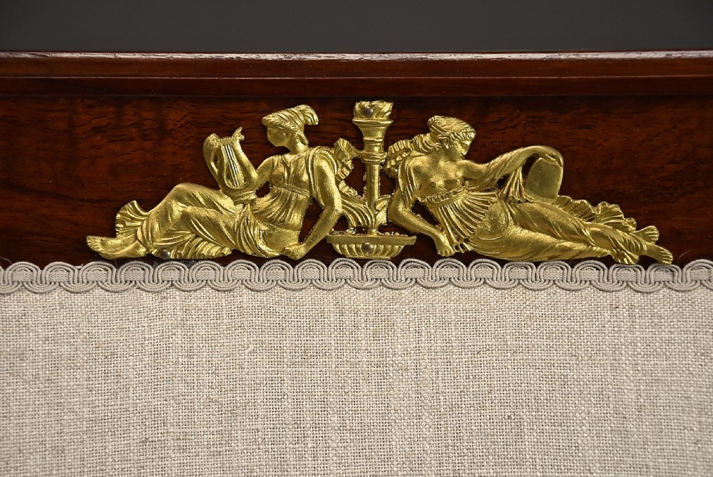 A pair of early 20th-century French Empire style mahogany armchairs featuring light neutral upholstery and gilt bronze mounts. View VII