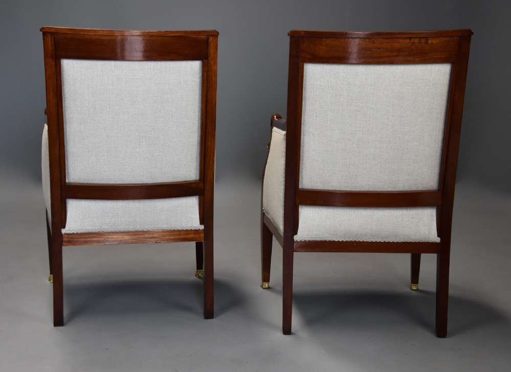 A pair of early 20th-century French Empire style mahogany armchairs featuring light neutral upholstery and gilt bronze mounts. View XIII