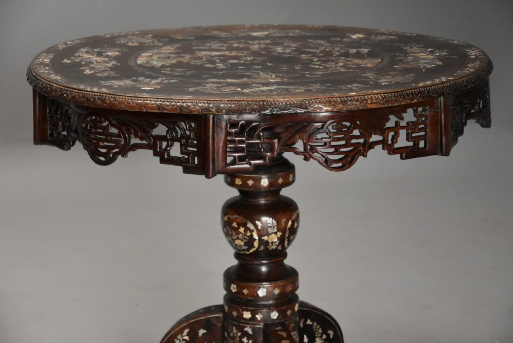 A late 19th century circular dark hardwood centre table featuring mother of pearl floral inlay, a carved openwork apron, and a tripod pedestal base. View III