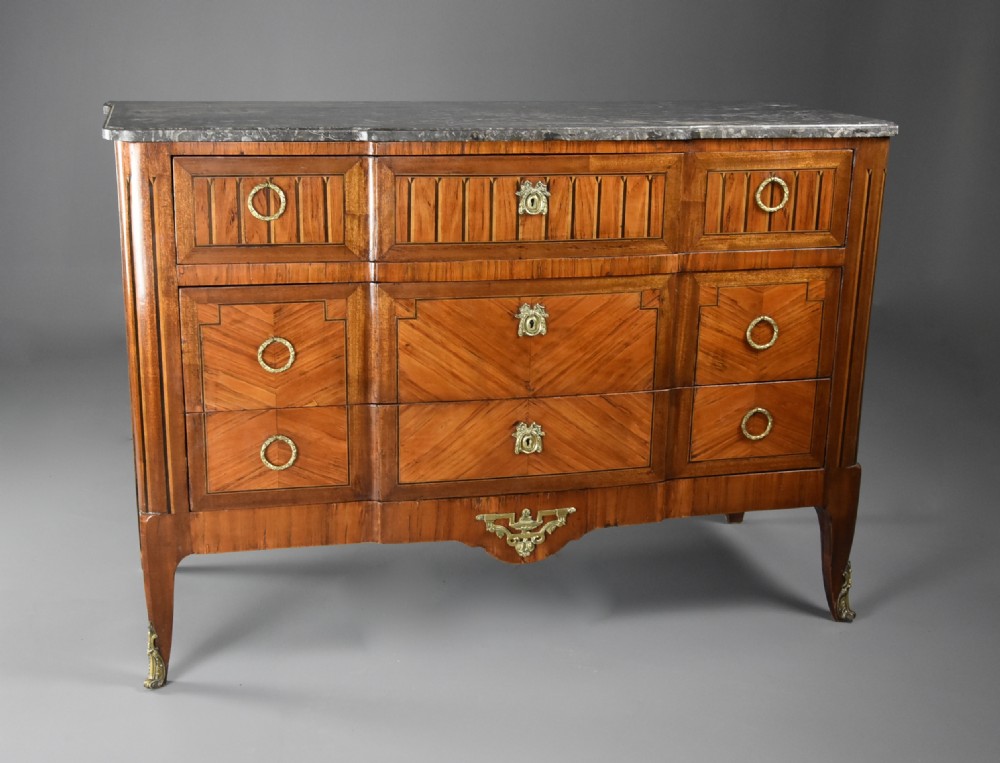 A late nineteenth-century French Louis XVI style tulipwood breakfront commode featuring inlaid parquetry panels, ring-pull brass handles, and a fitted grey marble top. View V