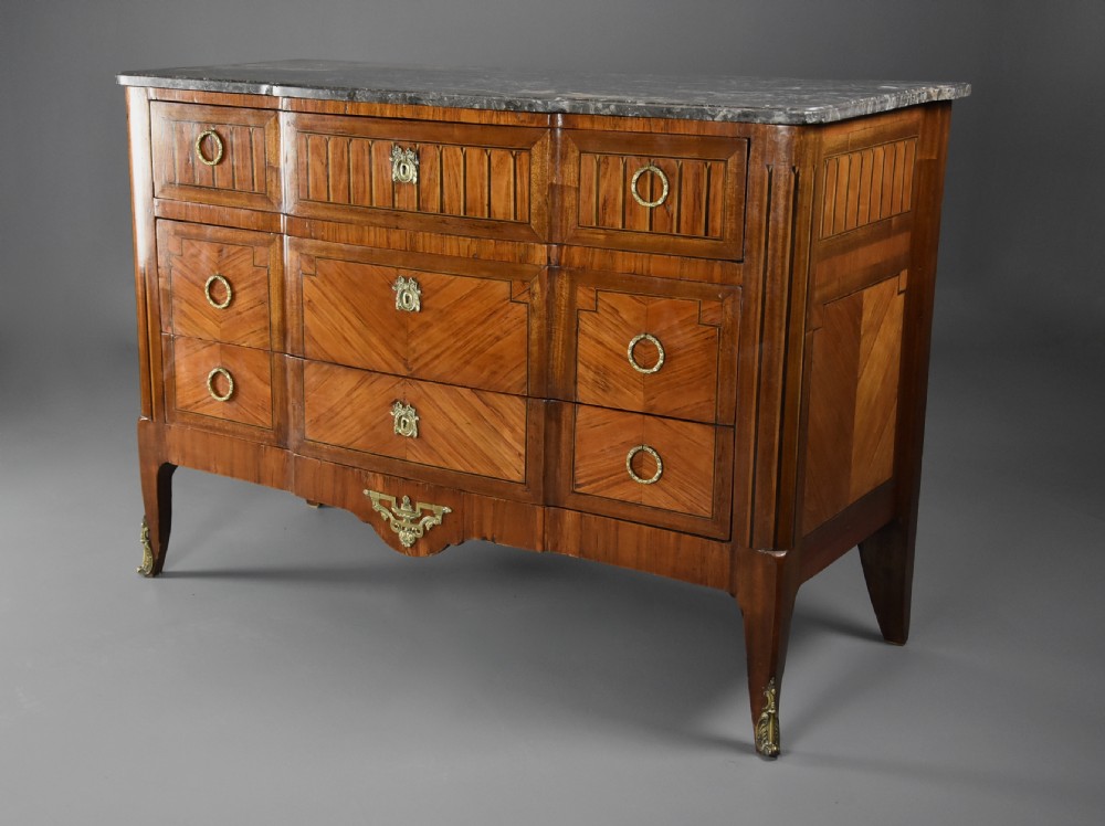 A late nineteenth-century French Louis XVI style tulipwood breakfront commode featuring inlaid parquetry panels, ring-pull brass handles, and a fitted grey marble top. View VII