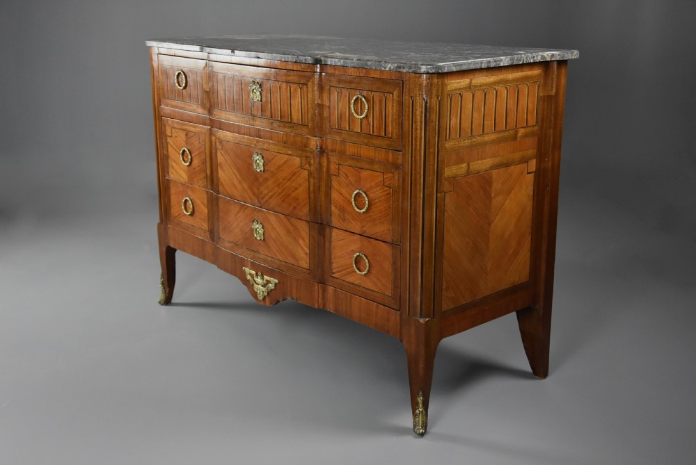 A late nineteenth-century French Louis XVI style tulipwood breakfront commode featuring inlaid parquetry panels, ring-pull brass handles, and a fitted grey marble top. View VIII
