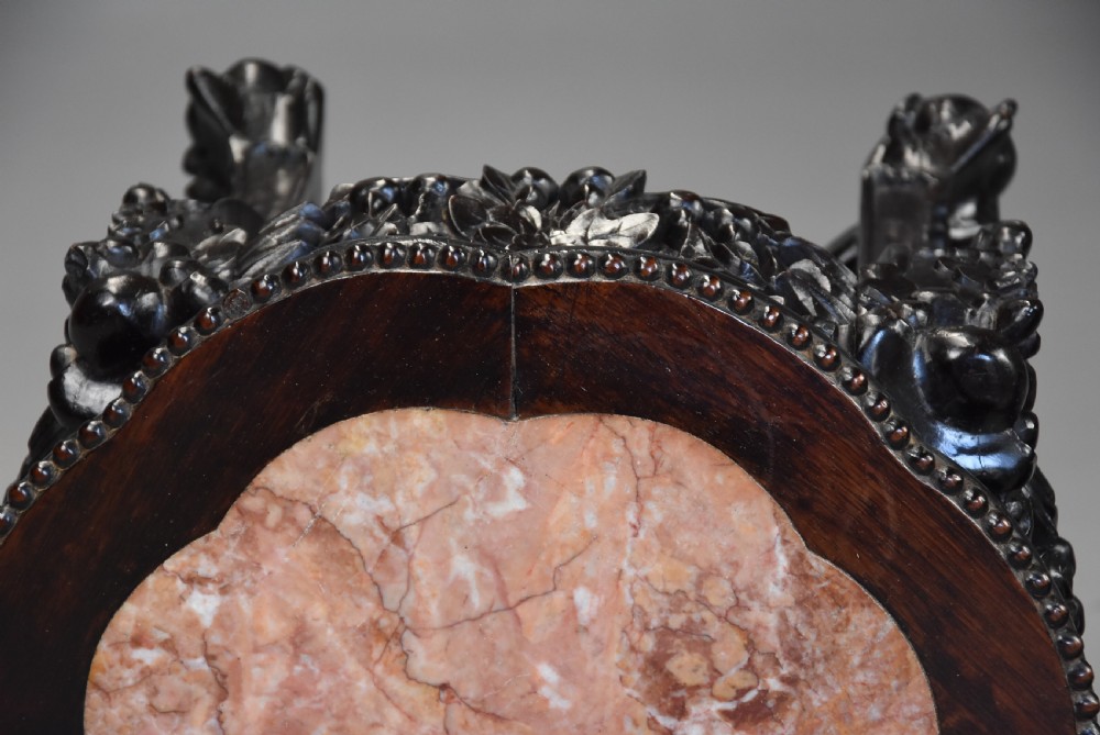 A pair of late nineteenth-century dark hardwood Chinese pot stands featuring carved foliage aprons, cabriole legs, and inset circular pink marble tops. View VII
