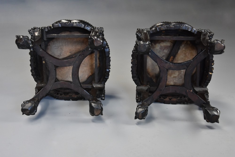 A pair of late nineteenth-century dark hardwood Chinese pot stands featuring carved foliage aprons, cabriole legs, and inset circular pink marble tops. View IX