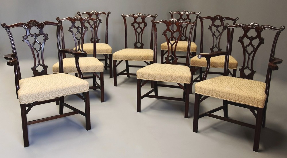 Set of eight late Victorian Chippendale style mahogany dining chairs featuring intricate pierced fretwork splats and light beige pattern-upholstered seats.
