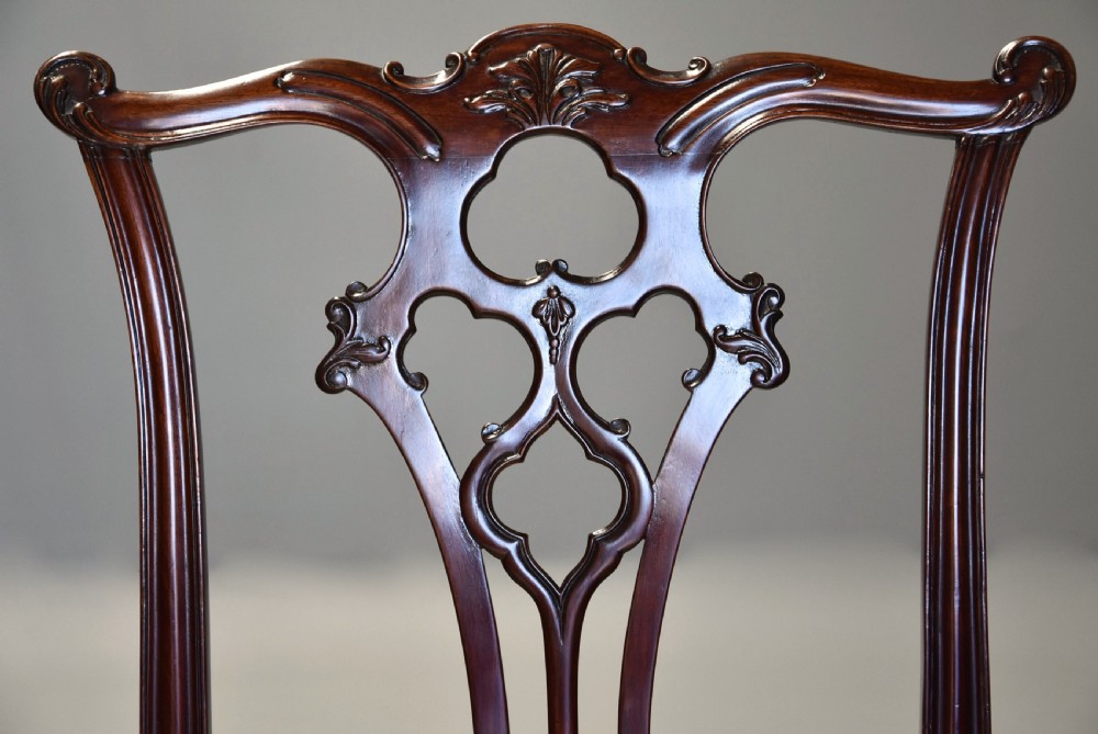 Set of eight late Victorian Chippendale style mahogany dining chairs featuring intricate pierced fretwork splats and light beige pattern-upholstered seats. View VIII