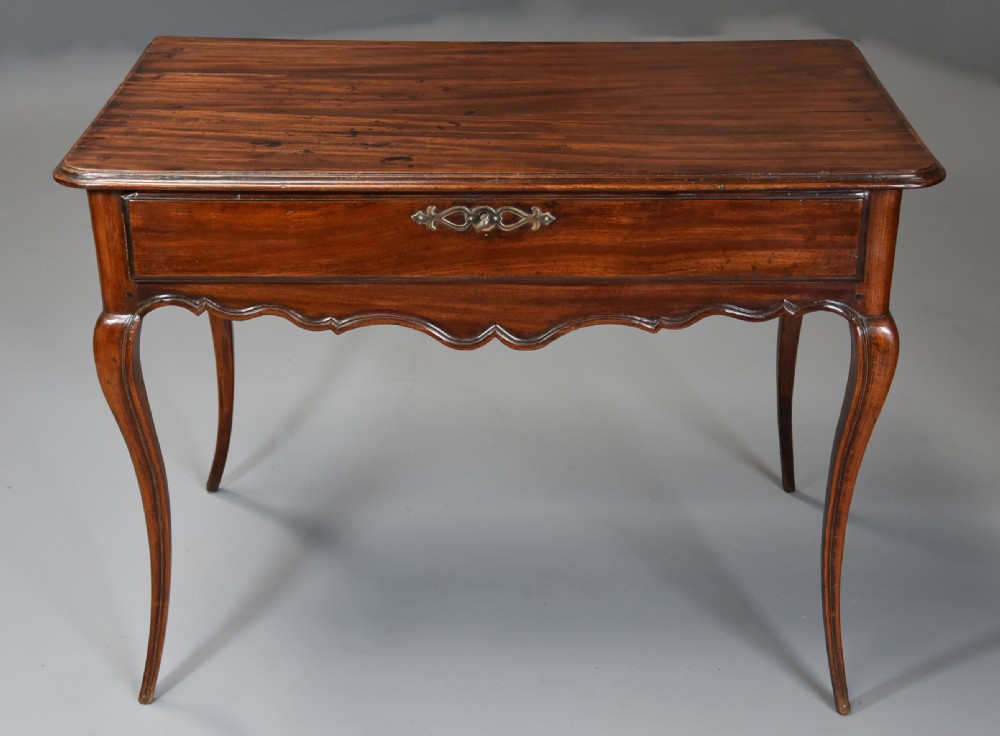 A late 18th-century French walnut side table featuring slender cabriole legs, a scalloped apron, and a single frieze drawer with a brass keyhole escutcheon. View II