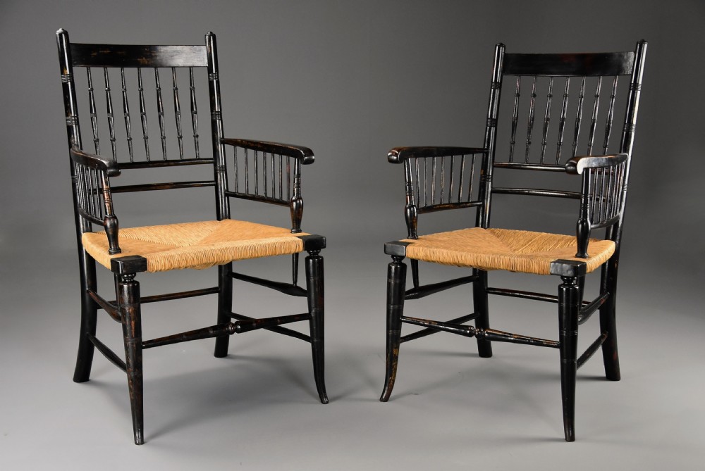 A pair of late nineteenth-century ebonised wooden armchairs featuring turned spindle backrests, woven rush seats, and turned legs with stretchers. View III