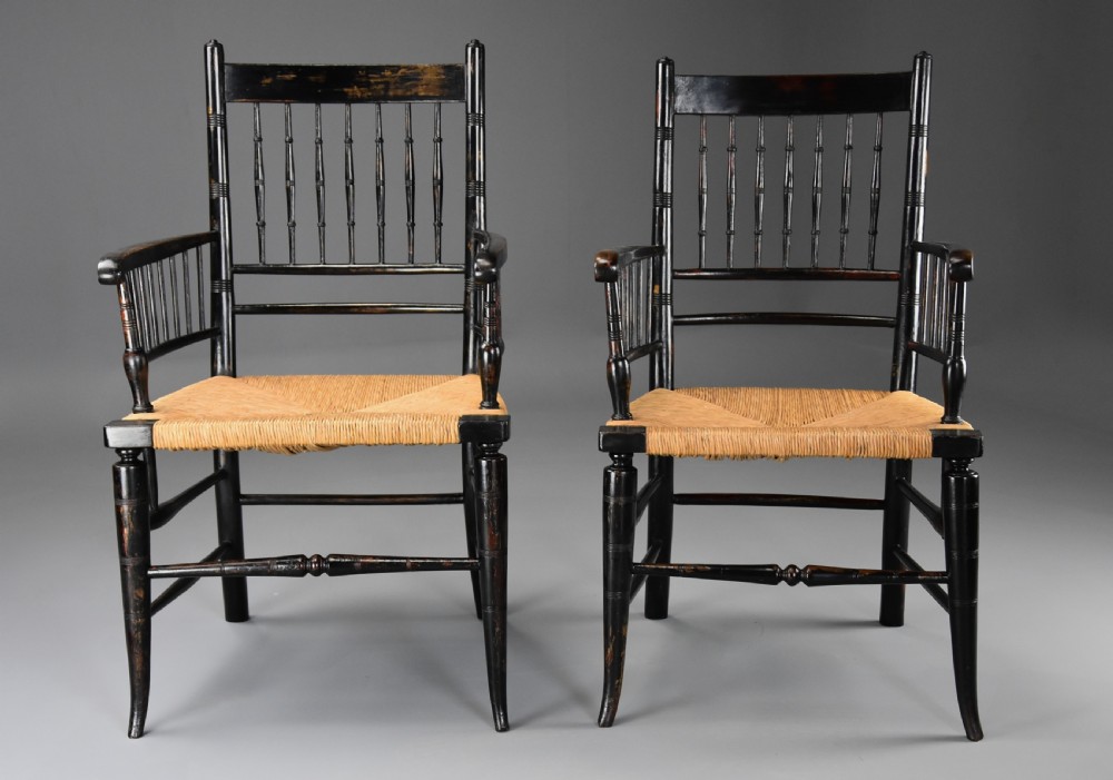 A pair of late nineteenth-century ebonised wooden armchairs featuring turned spindle backrests, woven rush seats, and turned legs with stretchers. View IV