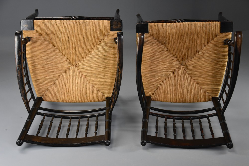 A pair of late nineteenth-century ebonised wooden armchairs featuring turned spindle backrests, woven rush seats, and turned legs with stretchers. View VII