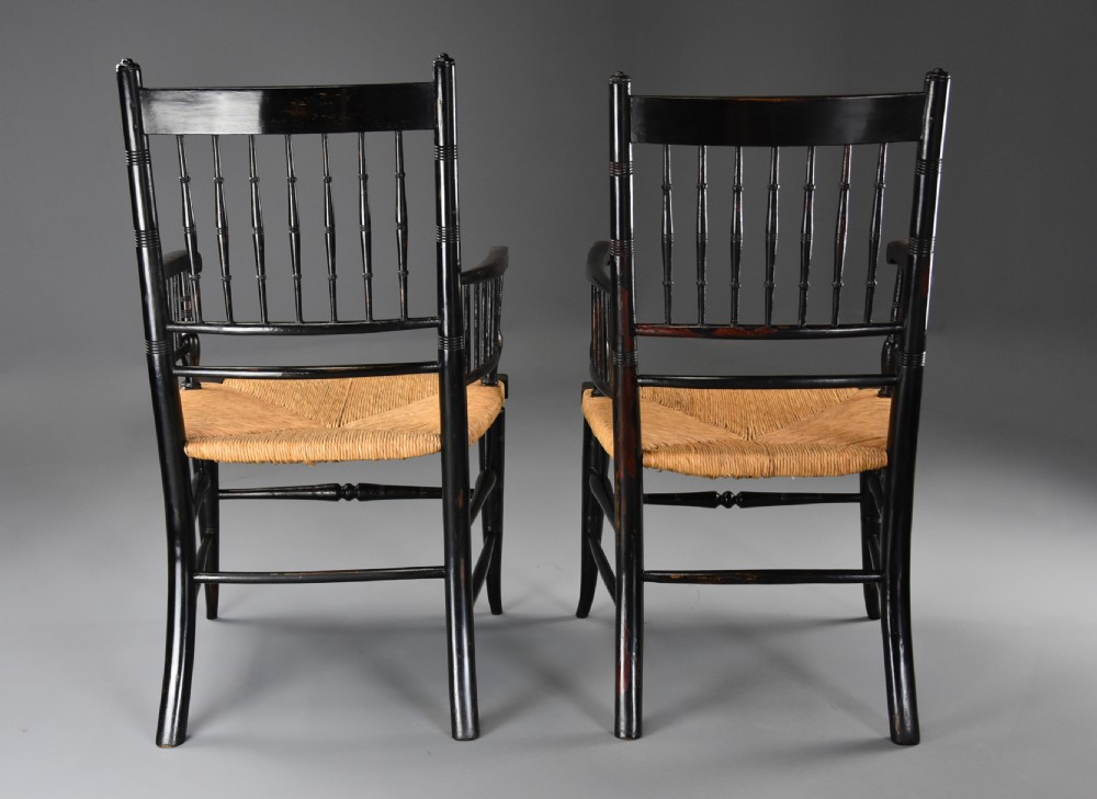 A pair of late nineteenth-century ebonised wooden armchairs featuring turned spindle backrests, woven rush seats, and turned legs with stretchers. View XVII
