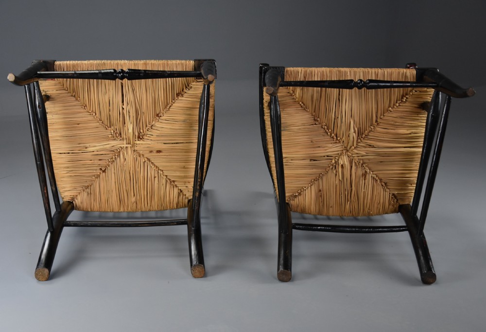 A pair of late nineteenth-century ebonised wooden armchairs featuring turned spindle backrests, woven rush seats, and turned legs with stretchers. View XVIII