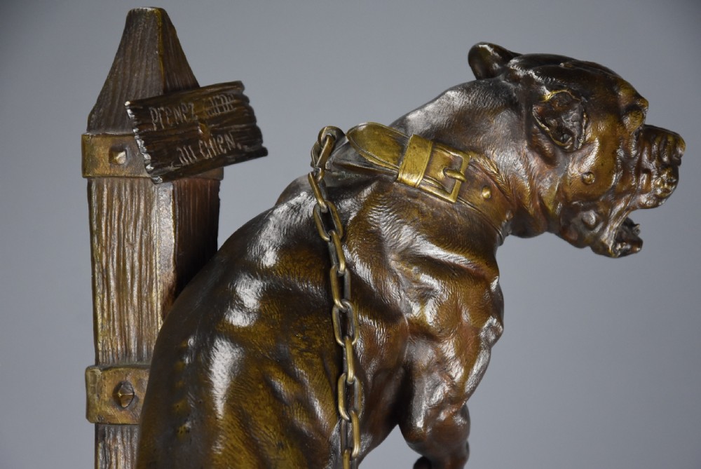 A 19th-century dark bronze sculpture of a chained guard dog rearing against a post, mounted on a brass collar and red veined marble base. View IX