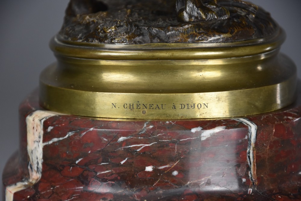 A 19th-century dark bronze sculpture of a chained guard dog rearing against a post, mounted on a brass collar and red veined marble base. View XX