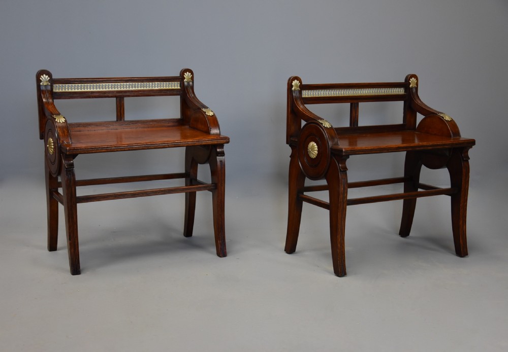 A pair of late nineteenth-century dark oak hall benches featuring carved side roundels, brass mounts, and a spindle gallery back. View III