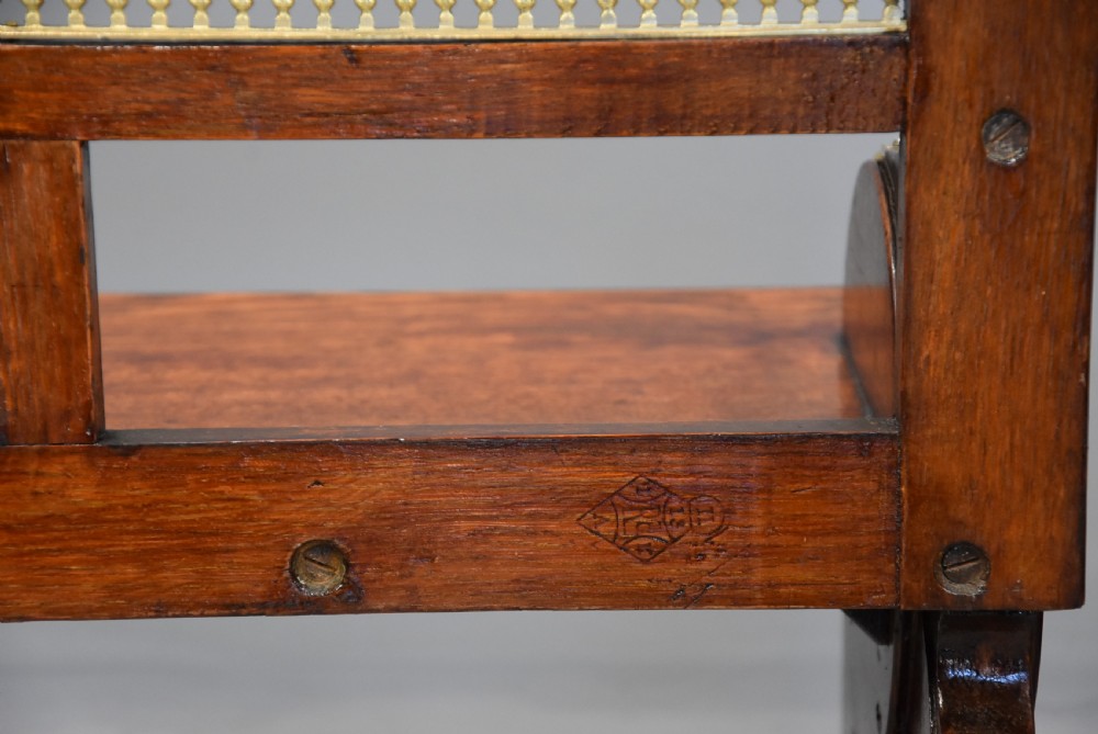 A pair of late nineteenth-century dark oak hall benches featuring carved side roundels, brass mounts, and a spindle gallery back. View XII