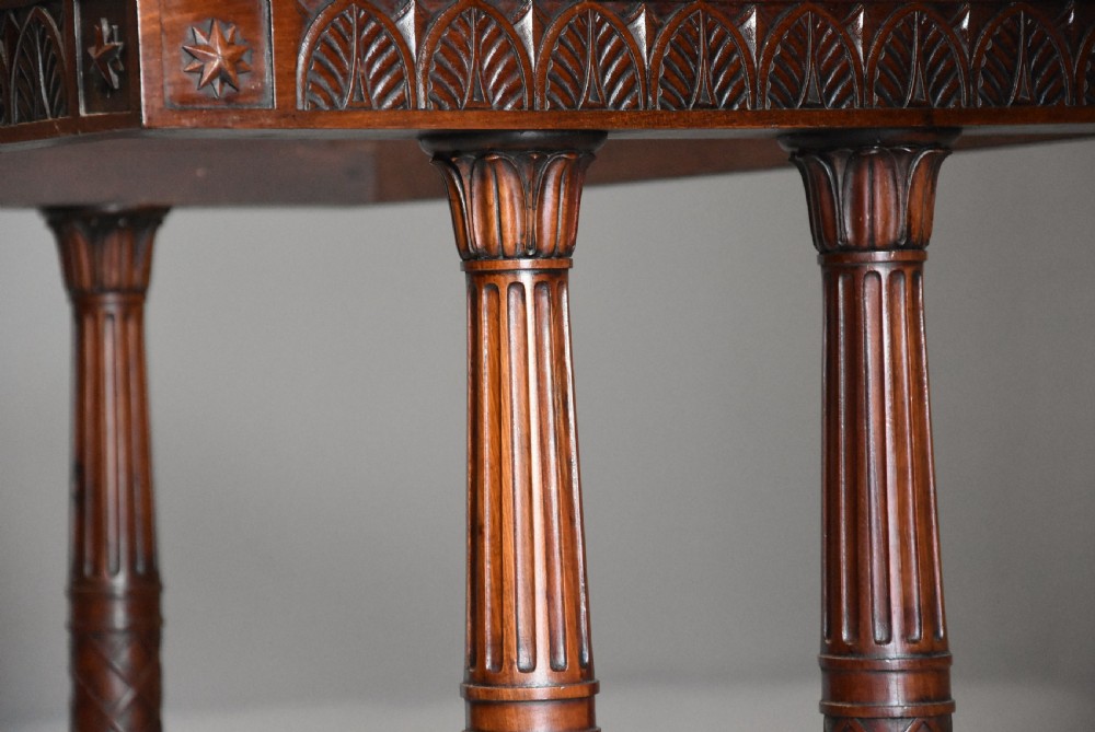 An early 19th-century French Empire mahogany centre table featuring a light marble top, carved frieze, fluted columns, and a trestle base. View VII