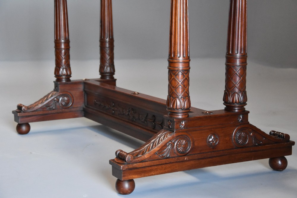 An early 19th-century French Empire mahogany centre table featuring a light marble top, carved frieze, fluted columns, and a trestle base. View VIII