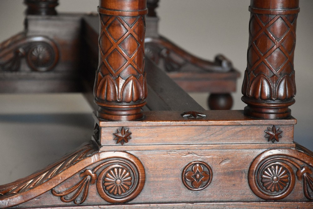 An early 19th-century French Empire mahogany centre table featuring a light marble top, carved frieze, fluted columns, and a trestle base. View IX