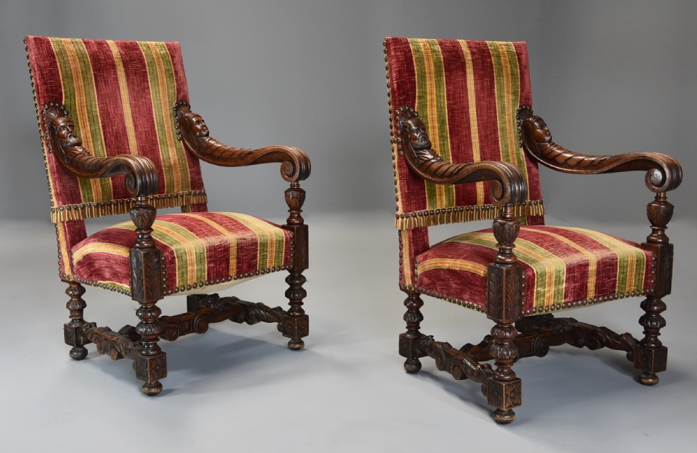 Pair of nineteenth-century French Baroque style walnut open armchairs upholstered in striped red and green velvet with carved human mask armrests. View II