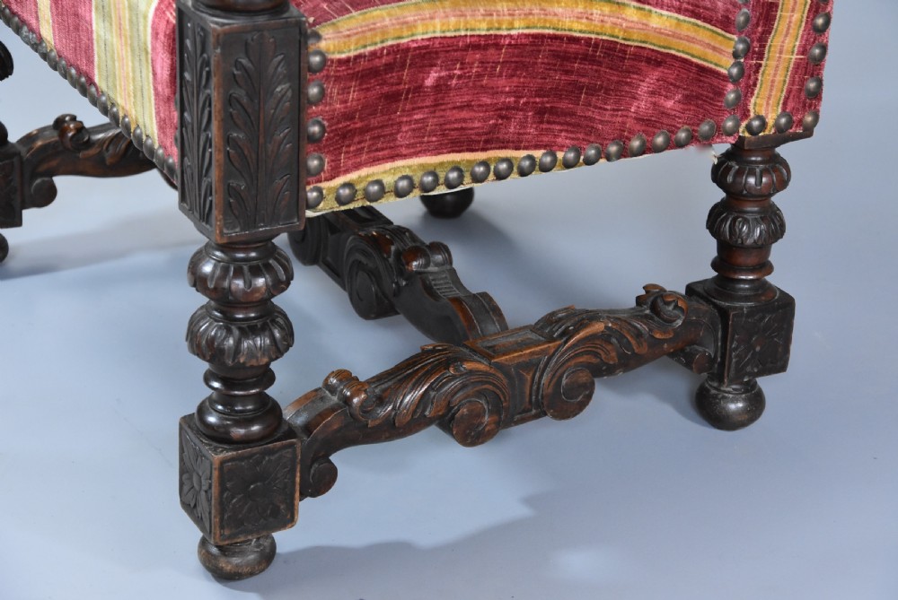 Pair of nineteenth-century French Baroque style walnut open armchairs upholstered in striped red and green velvet with carved human mask armrests. View X