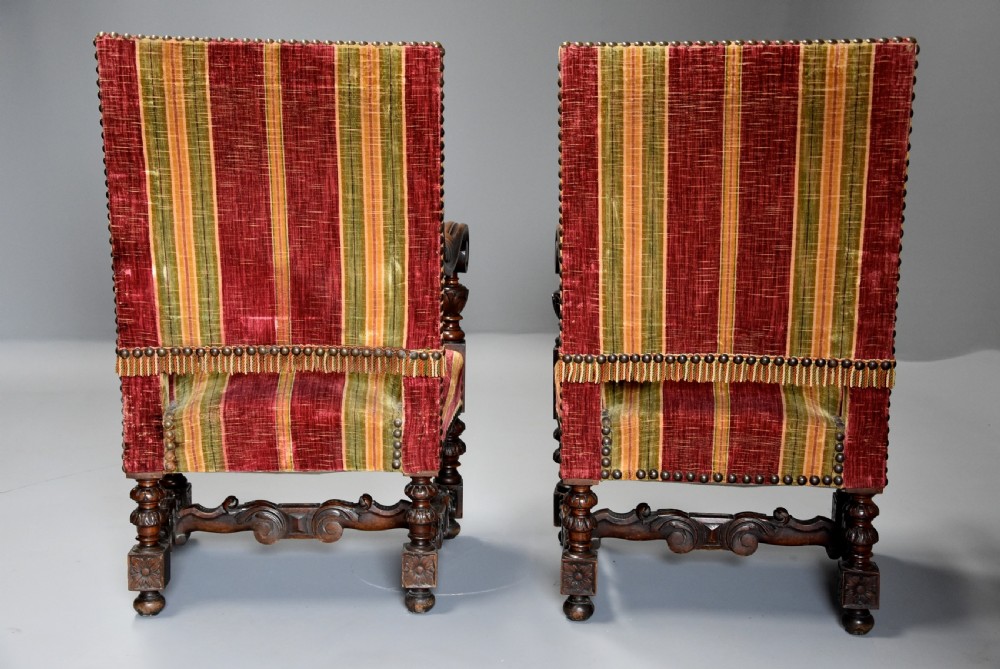 Pair of nineteenth-century French Baroque style walnut open armchairs upholstered in striped red and green velvet with carved human mask armrests. View XII