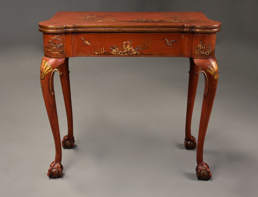 An early twentieth-century red lacquered games table with gilded Chinoiserie designs, cabriole legs, and ball and claw feet. View II