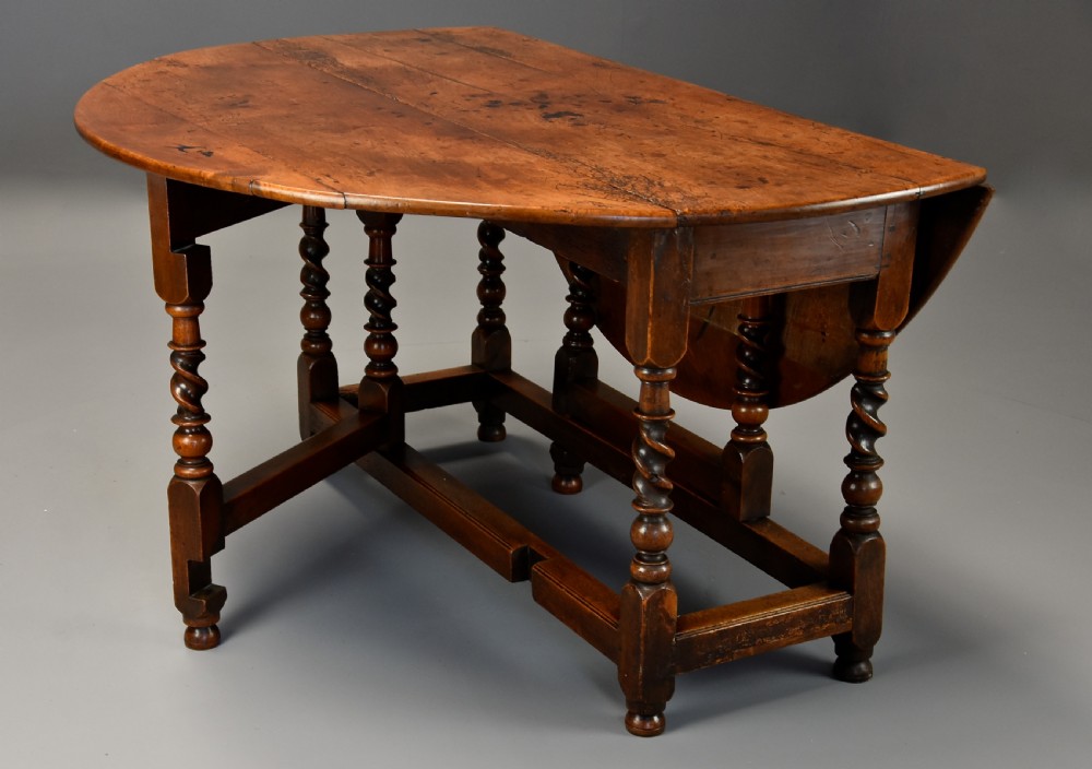 A 17th-century walnut gateleg table with extended oval drop leaves and double barley twist turned legs supported by stretchers. View VIII