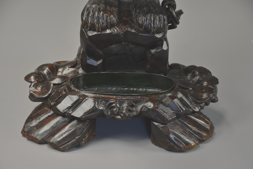 A late 19th-century carved wood Black Forest hall stand depicting an upright bear on a carved rockwork base with an integrated metal drip tray. View XII