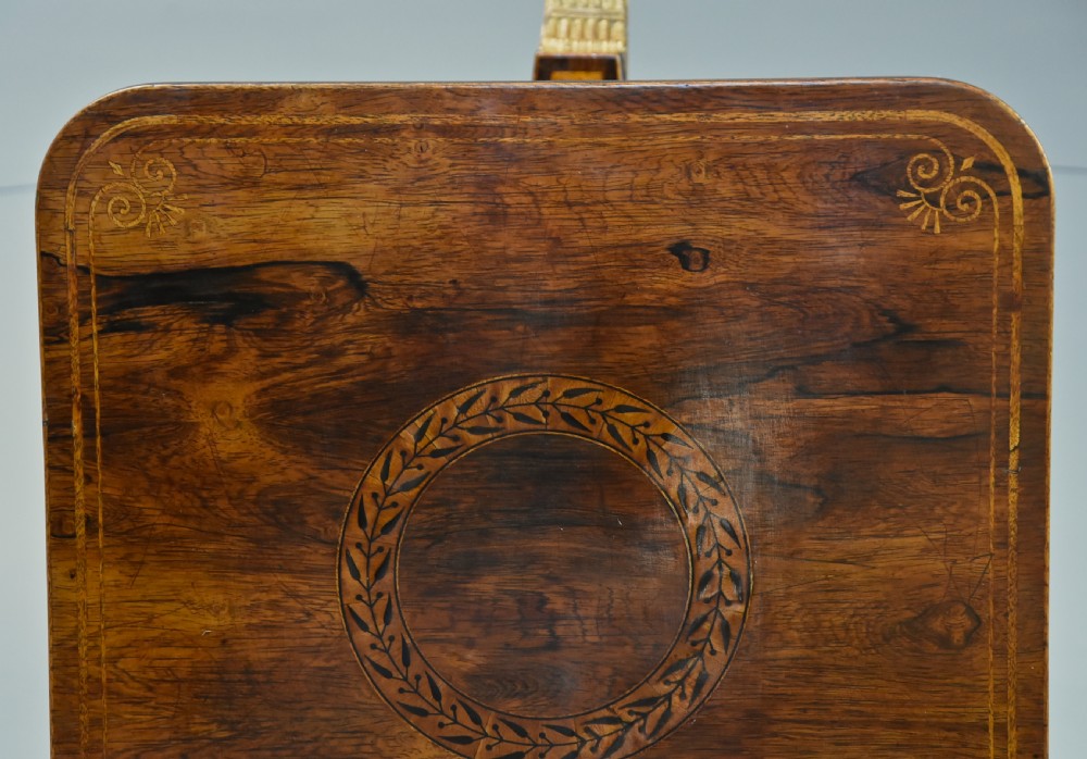 A 19th-century Regency rosewood occasional table featuring an inlaid square top, a circular gallery tier, a gilded central column, and a triform base with gilded feet. View VI