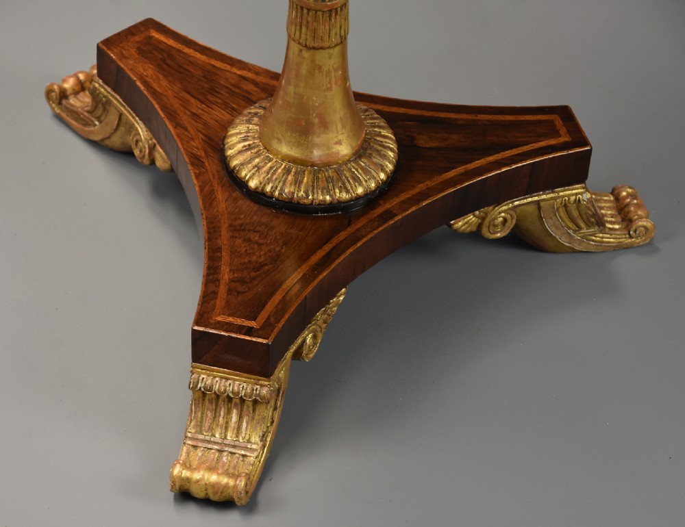 A 19th-century Regency rosewood occasional table featuring an inlaid square top, a circular gallery tier, a gilded central column, and a triform base with gilded feet. View X