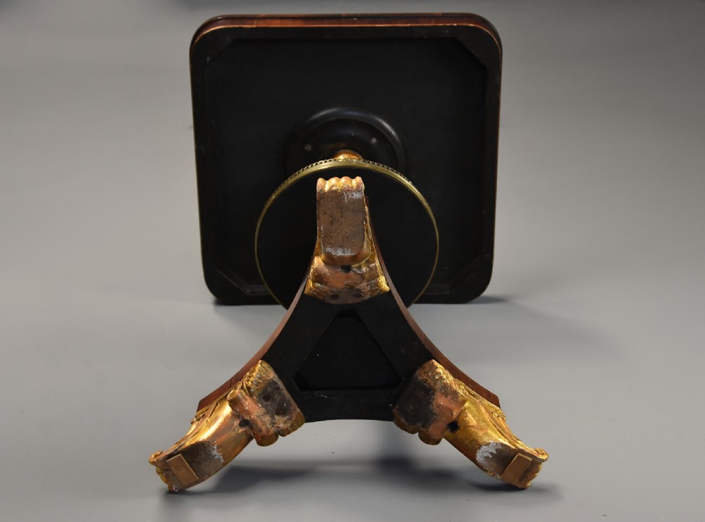 A 19th-century Regency rosewood occasional table featuring an inlaid square top, a circular gallery tier, a gilded central column, and a triform base with gilded feet. View XI