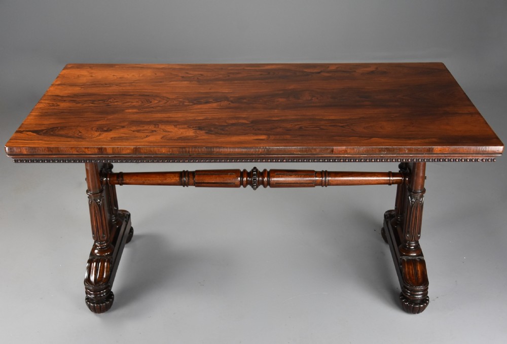 A William IV rosewood centre writing table featuring a rectangular top, beaded border, carved end supports, a central turned stretcher, and lobed feet. View III