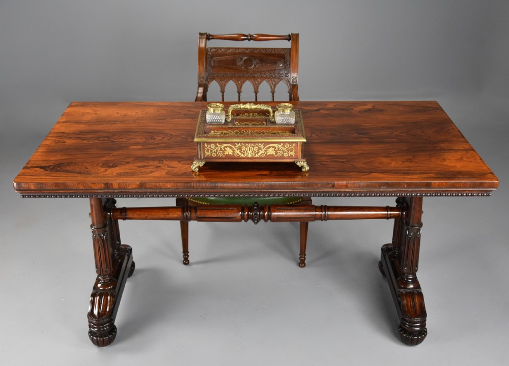A William IV rosewood centre writing table featuring a rectangular top, beaded border, carved end supports, a central turned stretcher, and lobed feet. View IV