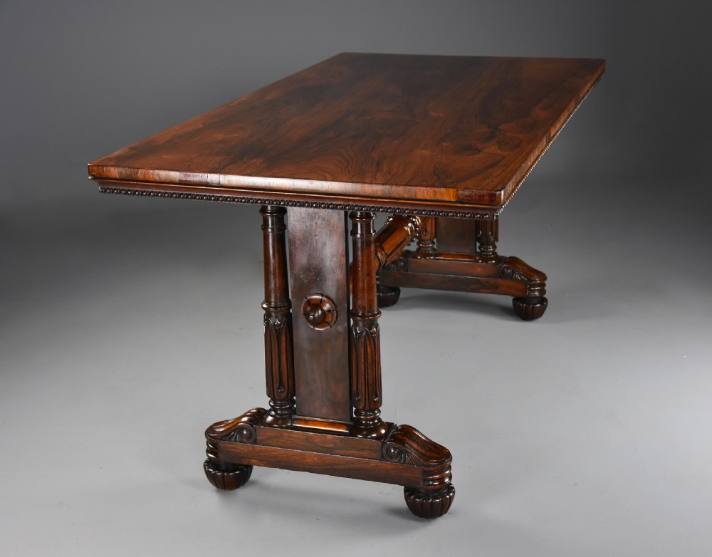 A William IV rosewood centre writing table featuring a rectangular top, beaded border, carved end supports, a central turned stretcher, and lobed feet. View V